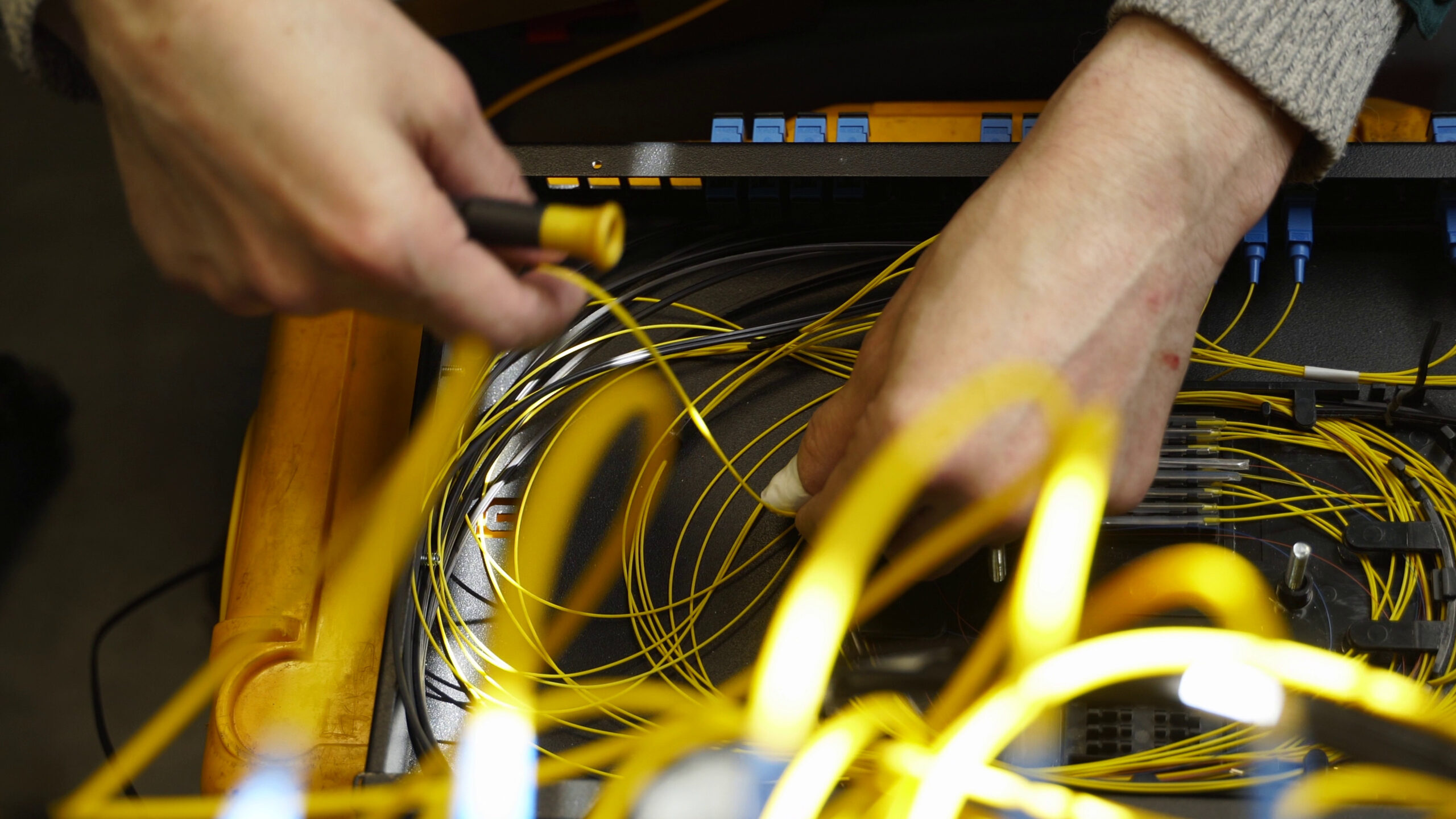 worker connects optical line internet wire in connection box service man soldering opt SBI  scaled